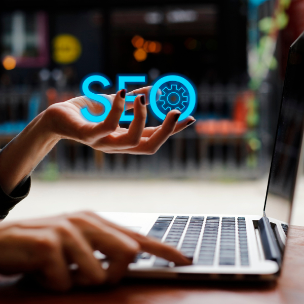 woman on laptop holding blue local SEO letters in her hand